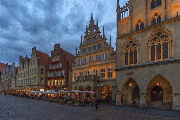 Illuminated historic gabled houses at blue hour