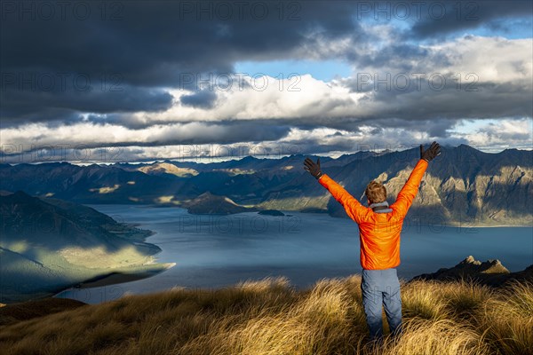 Hiker stretches his arms in the air