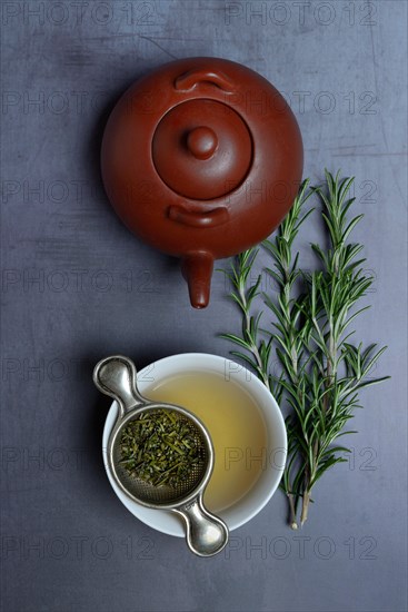 A cup of rosemary tea with tea strainer