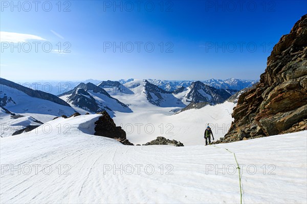 Mountaineer on a high climb on a long rope over a snowfield on the Altmann