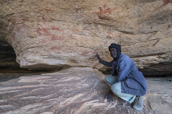 Man pointing out a Rock painting in the Unesco world heritage