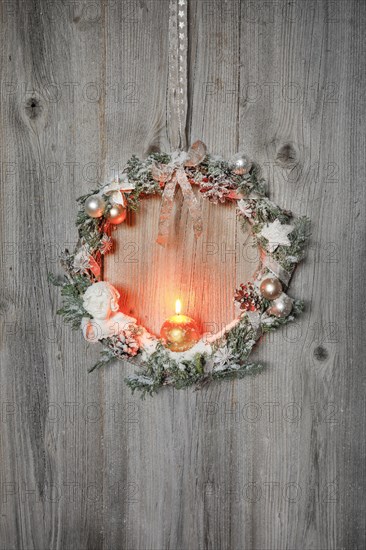 Christmas wreath on wooden wall with candle