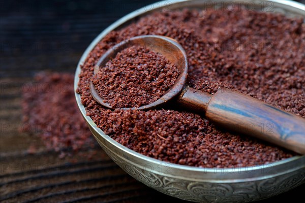 Sumac powder in bowl and spoon
