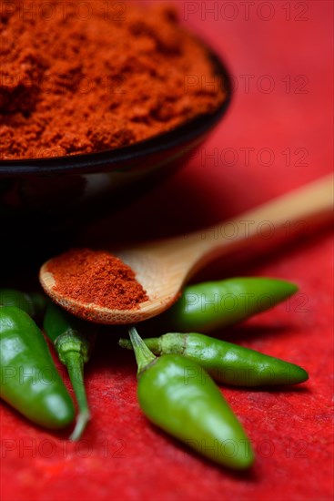 ( Capsicum annuum) Chilli powder in bowl and spoon and green chillies, paprika powder, chillies, kitchen spice, peppers