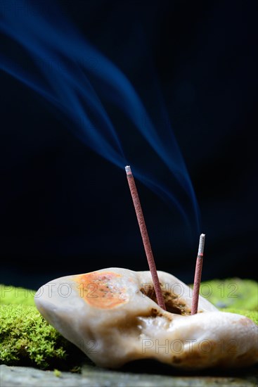 Burning incense sticks stuck in stone