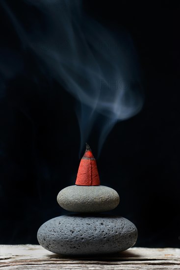 Burning incense cone on stones