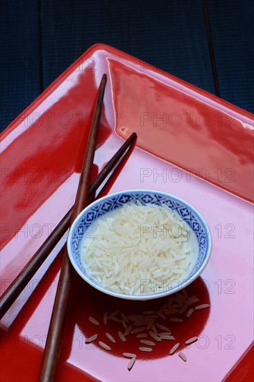 Rice grains in bowls and chopsticks