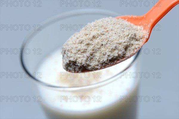 Tigernut flour in spoon and glass of milk