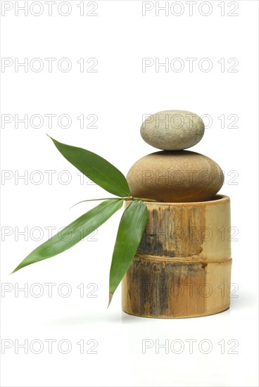 Stacked stones on bamboo cane and bamboo leaf