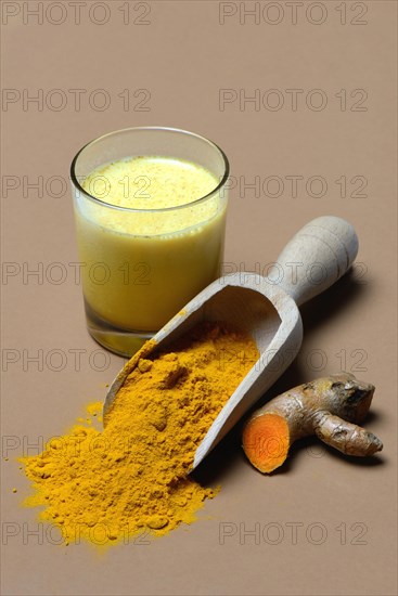 Turmeric-powder in shovel and -milk in glass