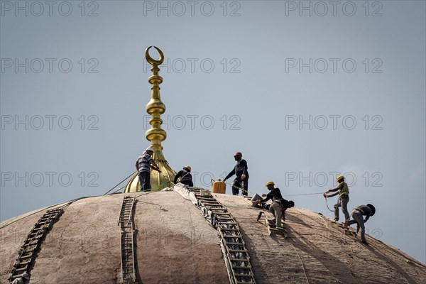 Worker on the dome of a mosque