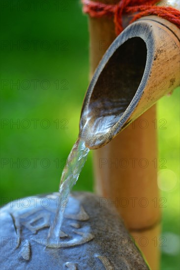 Japanese bamboo fountain and stone with inscription