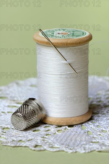 Thread roll with sewing needle and thimble
