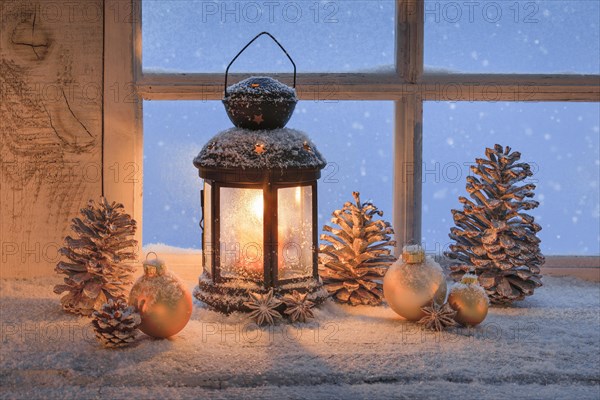 Lantern with Christmas decoration on windowsill