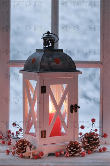 Lantern with Christmas decoration on windowsill