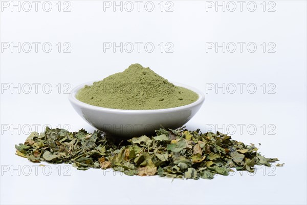 Moringa powder in bowl and moringa leaves