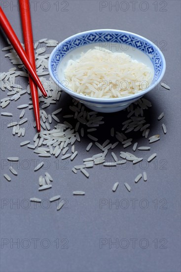 Rice grains in husk and chopsticks