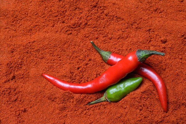 Red and green chilli peppers in chilli powder