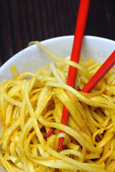 Chinese noodles in bowl with chopsticks