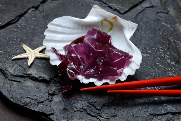 Red alga with sea salt in mussel shell and chopsticks