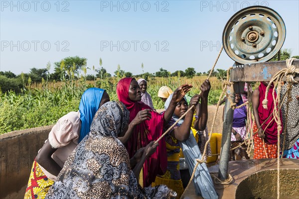 Colourful dressed women fetch water at the well