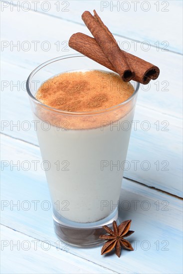 Cinnamon milk in glass with cinnamon sticks and star anise