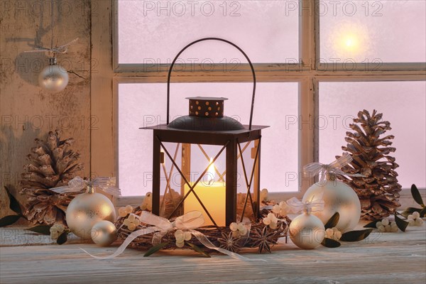 Lantern with Christmas decoration on windowsill