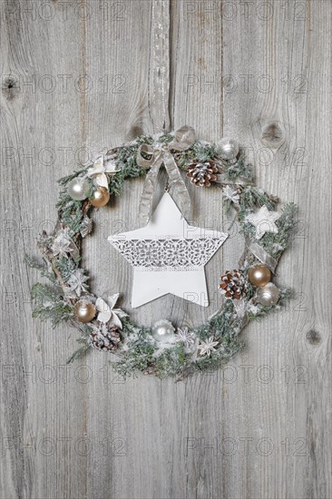 Christmas wreath on wooden wall with star