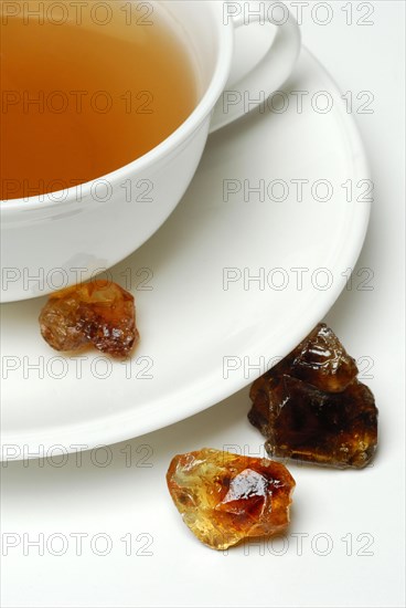 Cup of tea and brown rock candy