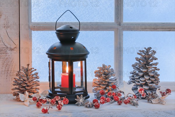 Lantern with Christmas decoration on windowsill