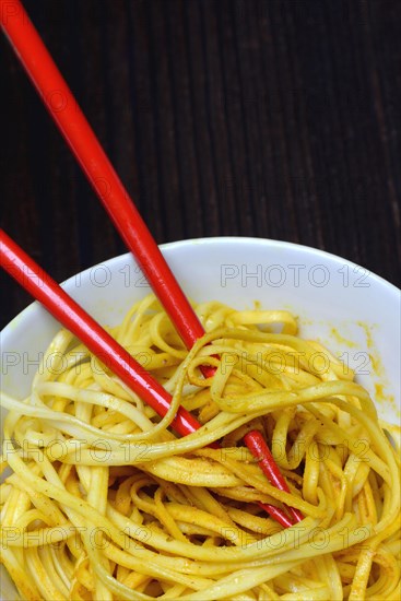 Chinese noodles in bowl with chopsticks