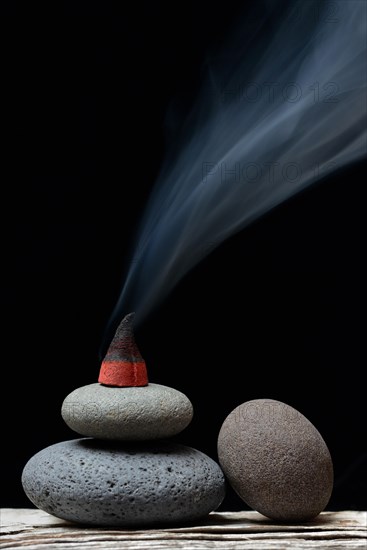 Burning incense cone on stones