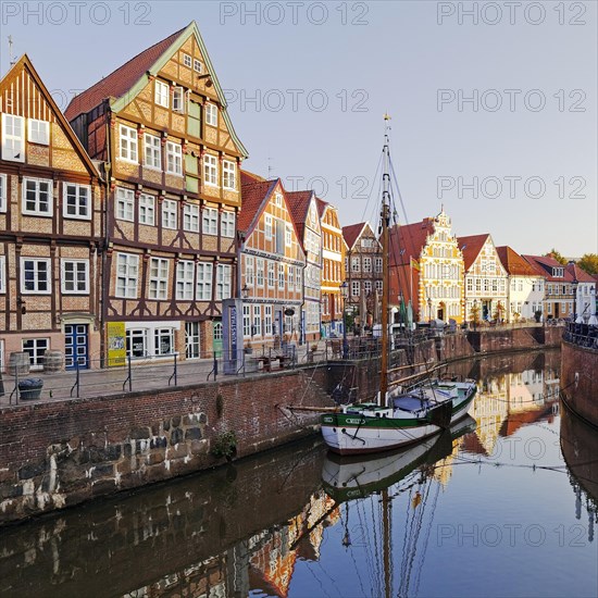 Historic merchant and warehouse houses at the Hanseatic port with the sailing ship Willi