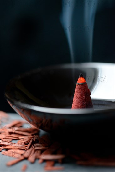 Burning incense cone and sandalwood