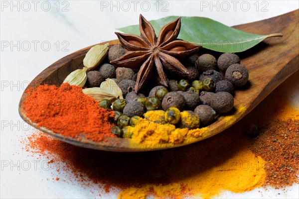 Various spices in wooden spoon