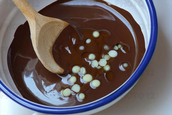 Liquid chocolate coating and melting cocoa butter with spoon