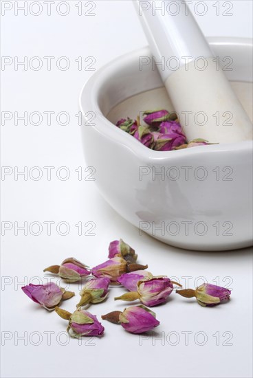 Dried rose buds are crushed in mortar