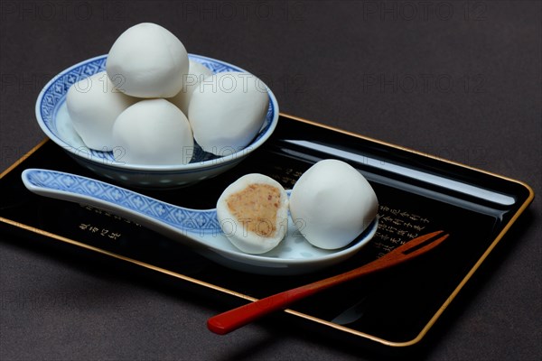 Glutinous rice balls with peanut filling in bowl and spoon