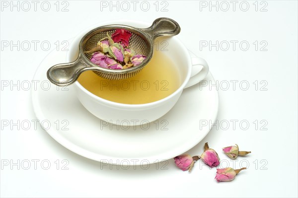 Rose tea in cup and rose buds