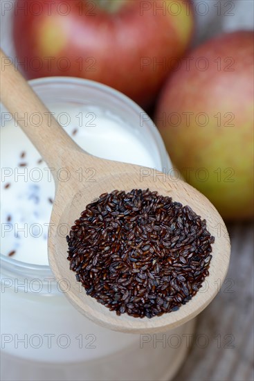 Psyllium plantain in cooking spoon on yoghurt glass and apples
