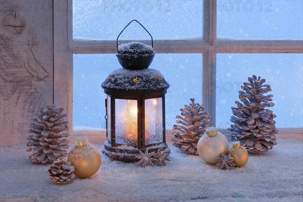 Lantern with Christmas decoration on windowsill