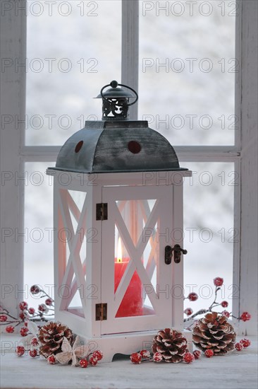 Lantern with Christmas decoration on windowsill