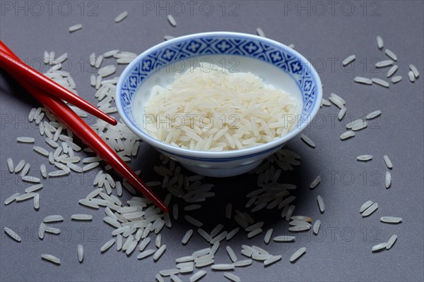 Rice grains in husk and chopsticks