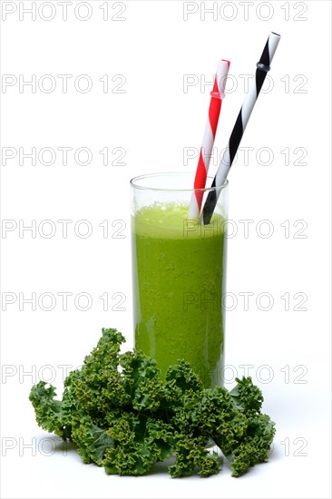 Kale smoothie in glass with drinking straw