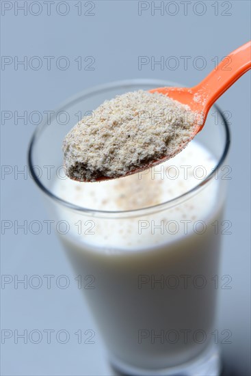 Tigernut flour in spoon and glass of milk