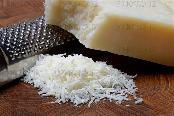 Grated Parmesan cheese and piece of Parmesan cheese