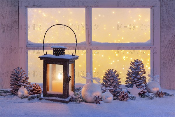 Lantern with Christmas decoration on windowsill