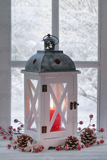 Lantern with Christmas decoration on windowsill