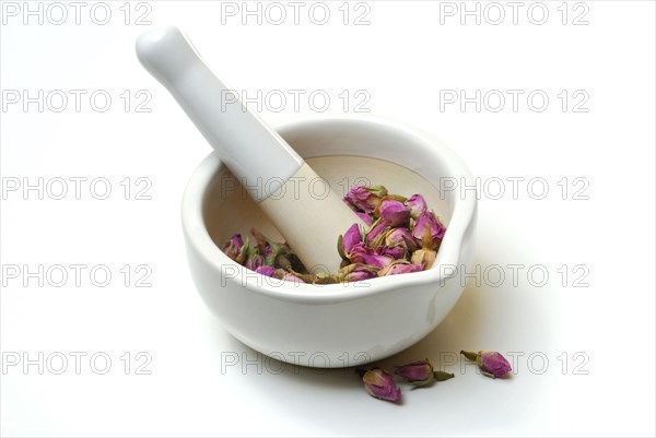 Dried rose buds are crushed in mortar