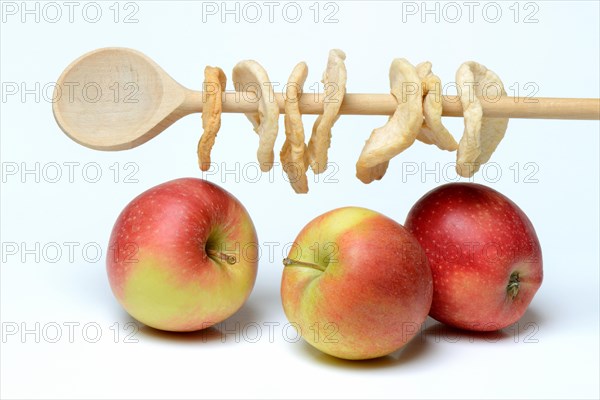 Apples and apple rings on wooden spoon